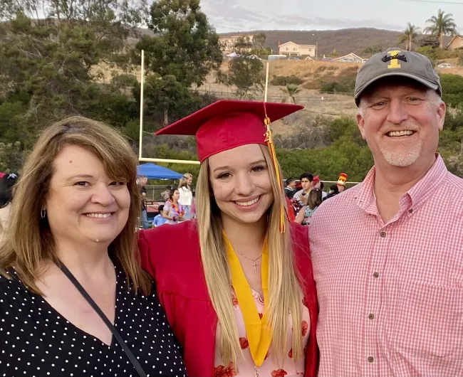 parents posing with young girl at high school graduation