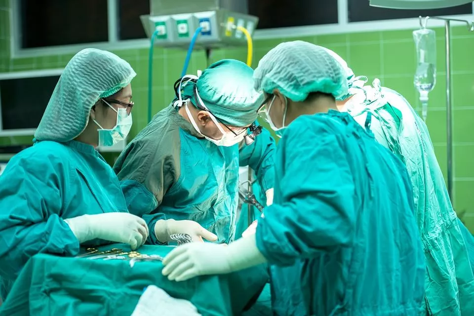 A surgeon and her team perform open surgery in an operating room.